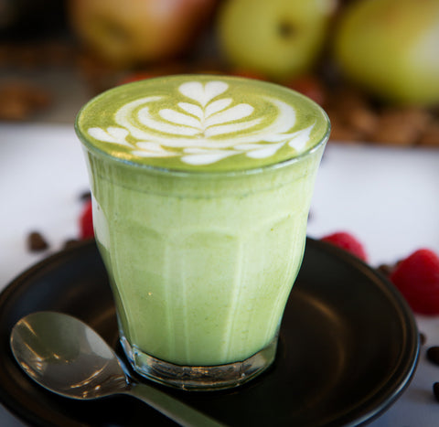 Matcha latté in glas op schotel